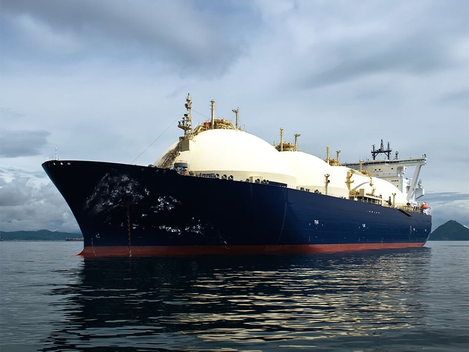 LNG vessel on the sea with shoreline in the background